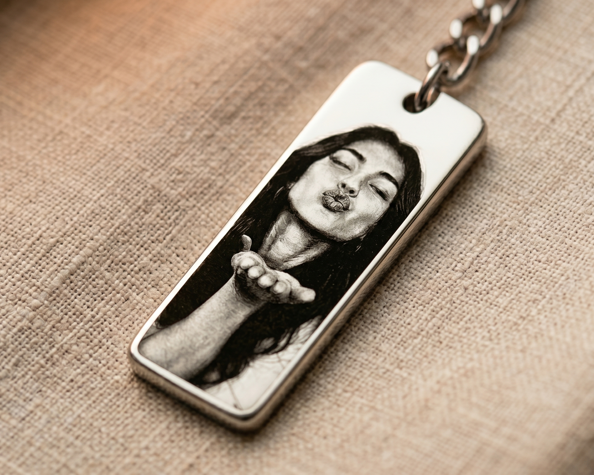 close-up of a vertical keychain pendant printed with a photo of a woman blowing a kiss