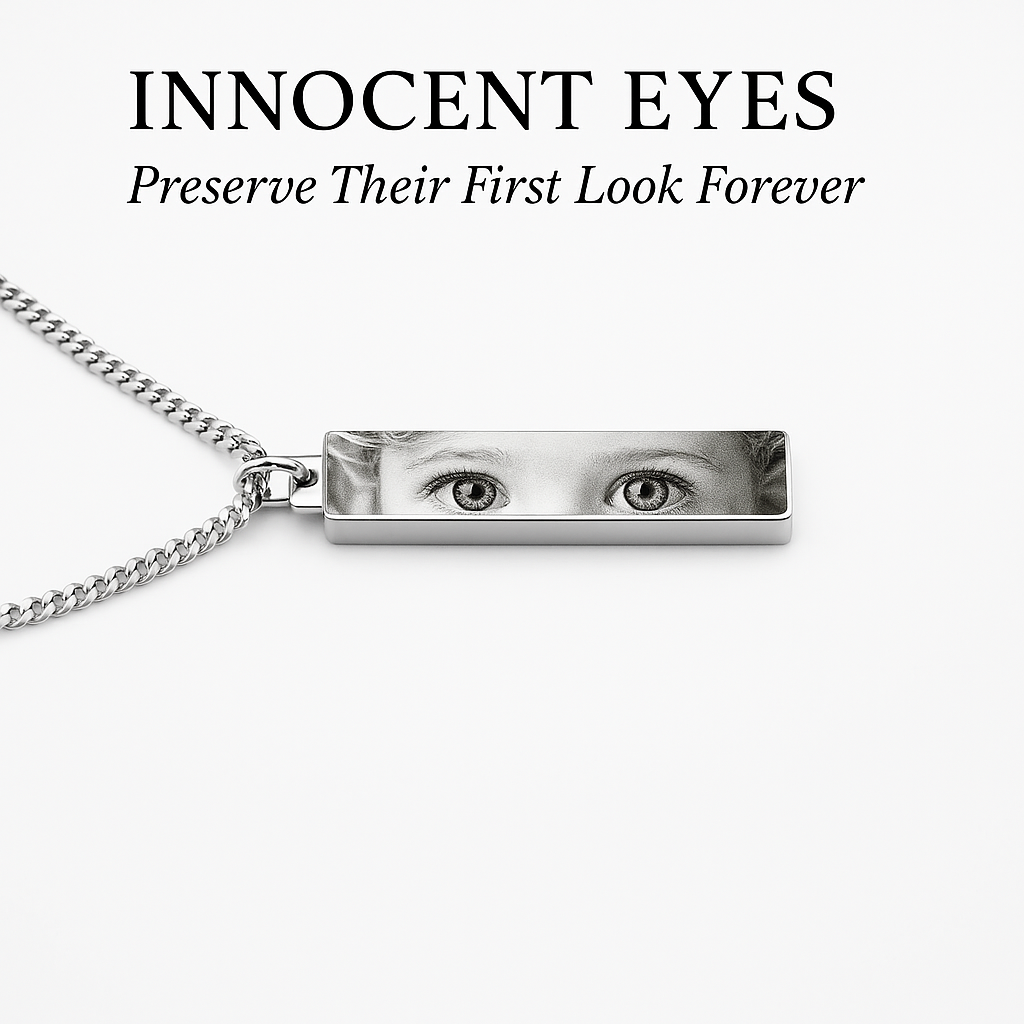 a silver rectangular necklace pendant that's printed on with the bright eyes of a toddler in grayscale