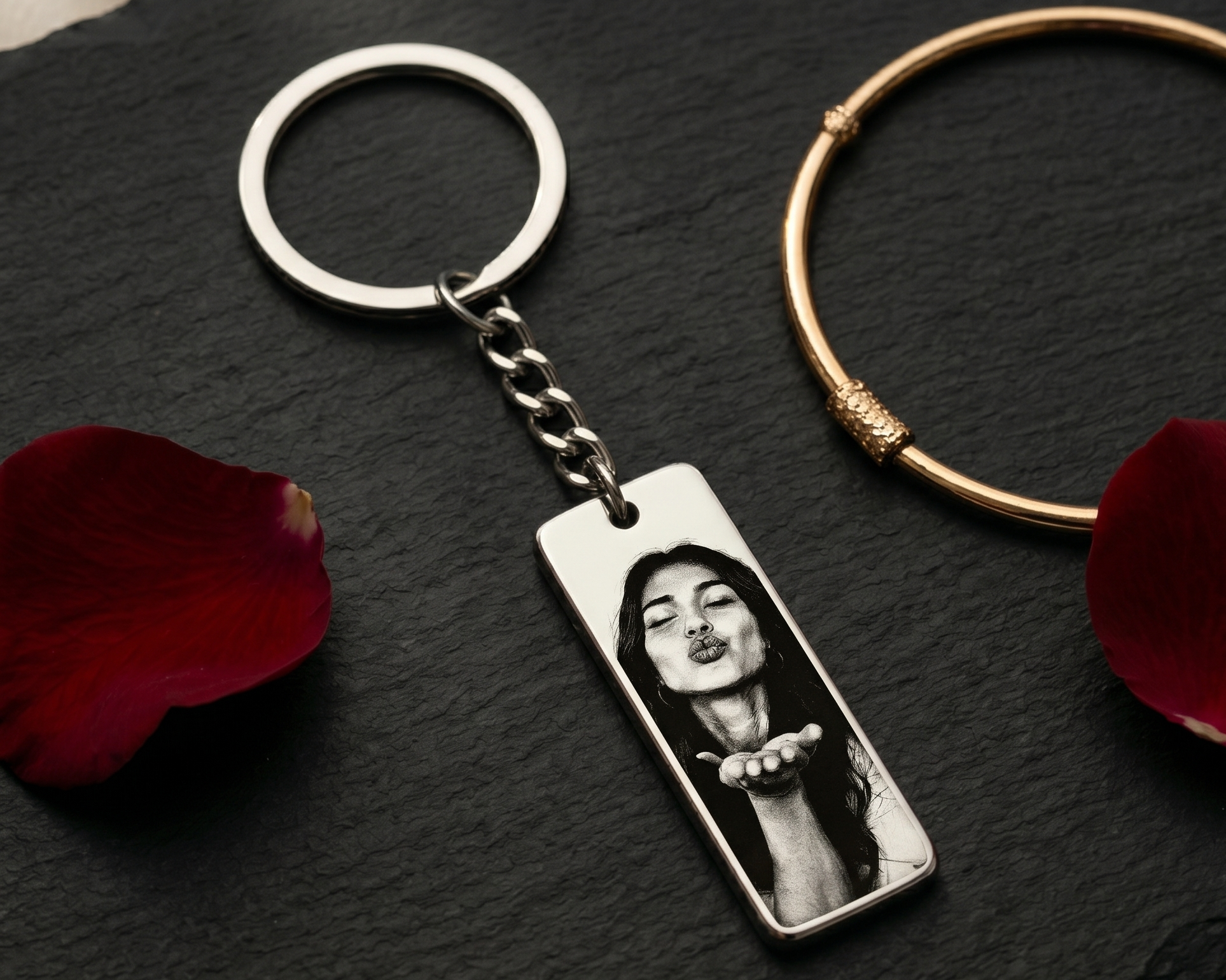 keychain featuring a woman blowing a kiss surrounded by rose petals on a dark wood surface