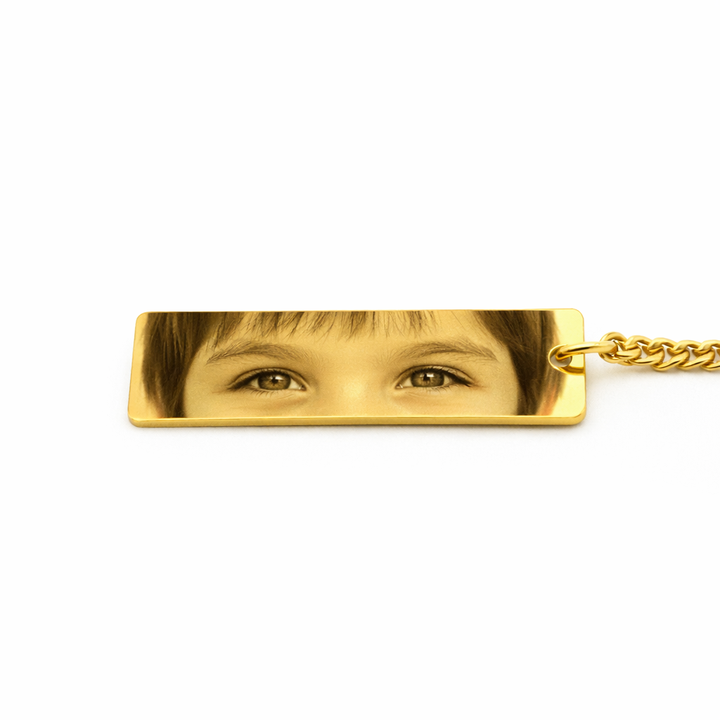 a gold keychain pendant featuring the eyes of a child in a sepia tone