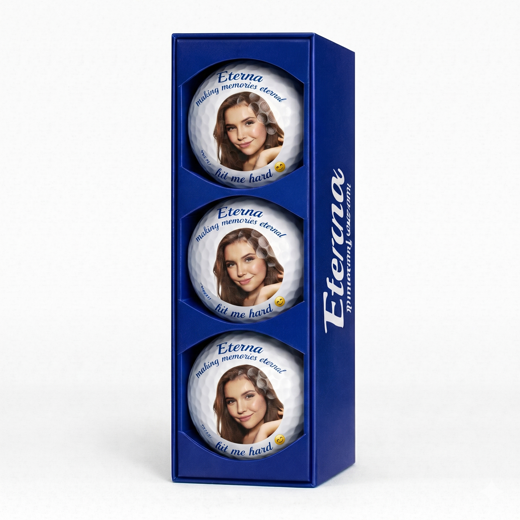 a set of three golf balls encased in a blue Eterna Customs box
