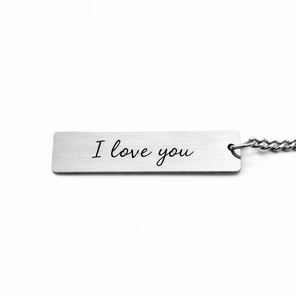 the back of a silver keychain pendant which features custom text in a casual script font, reads "i love you"