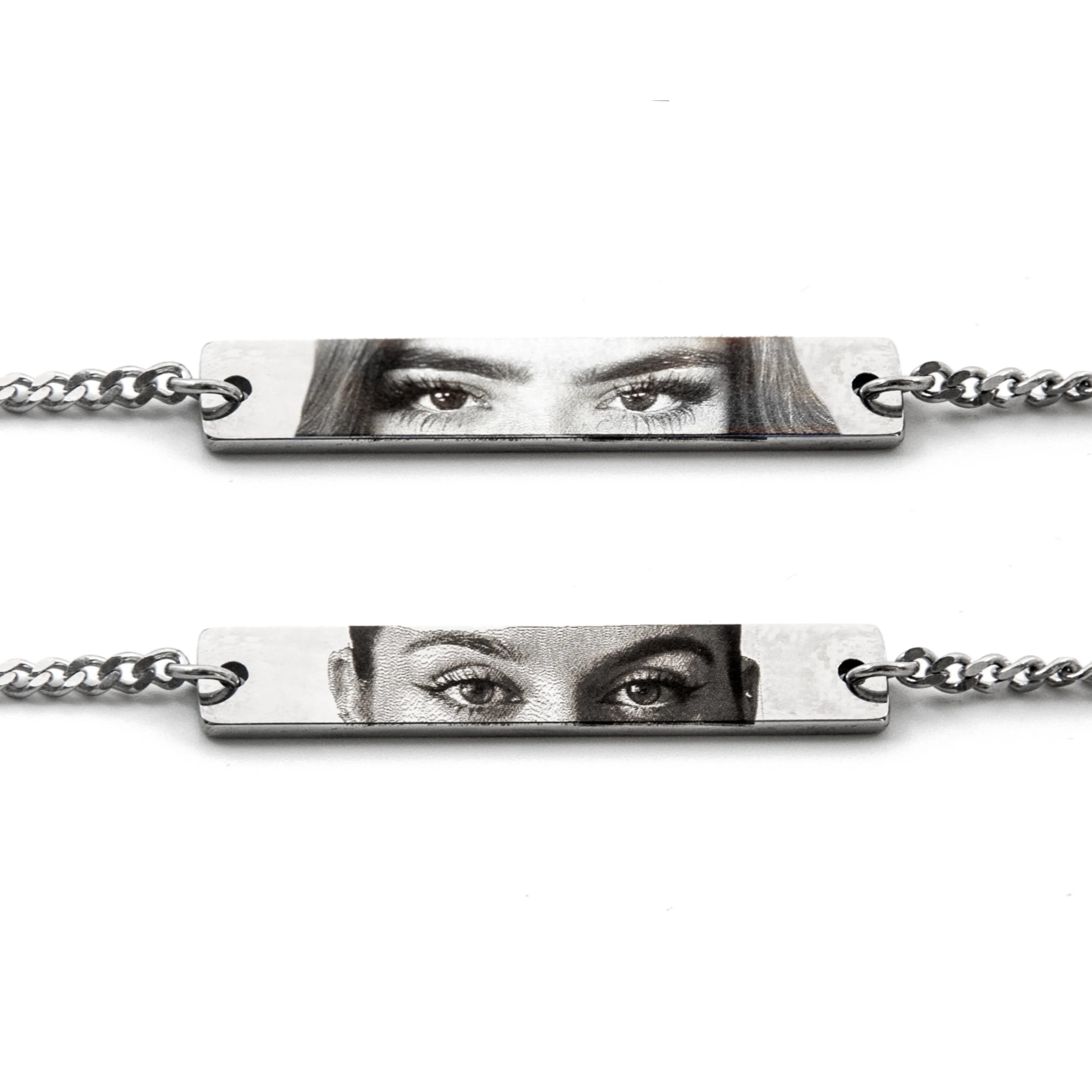 two silver bracelets featuring printed photos of different womens eyes in black and white