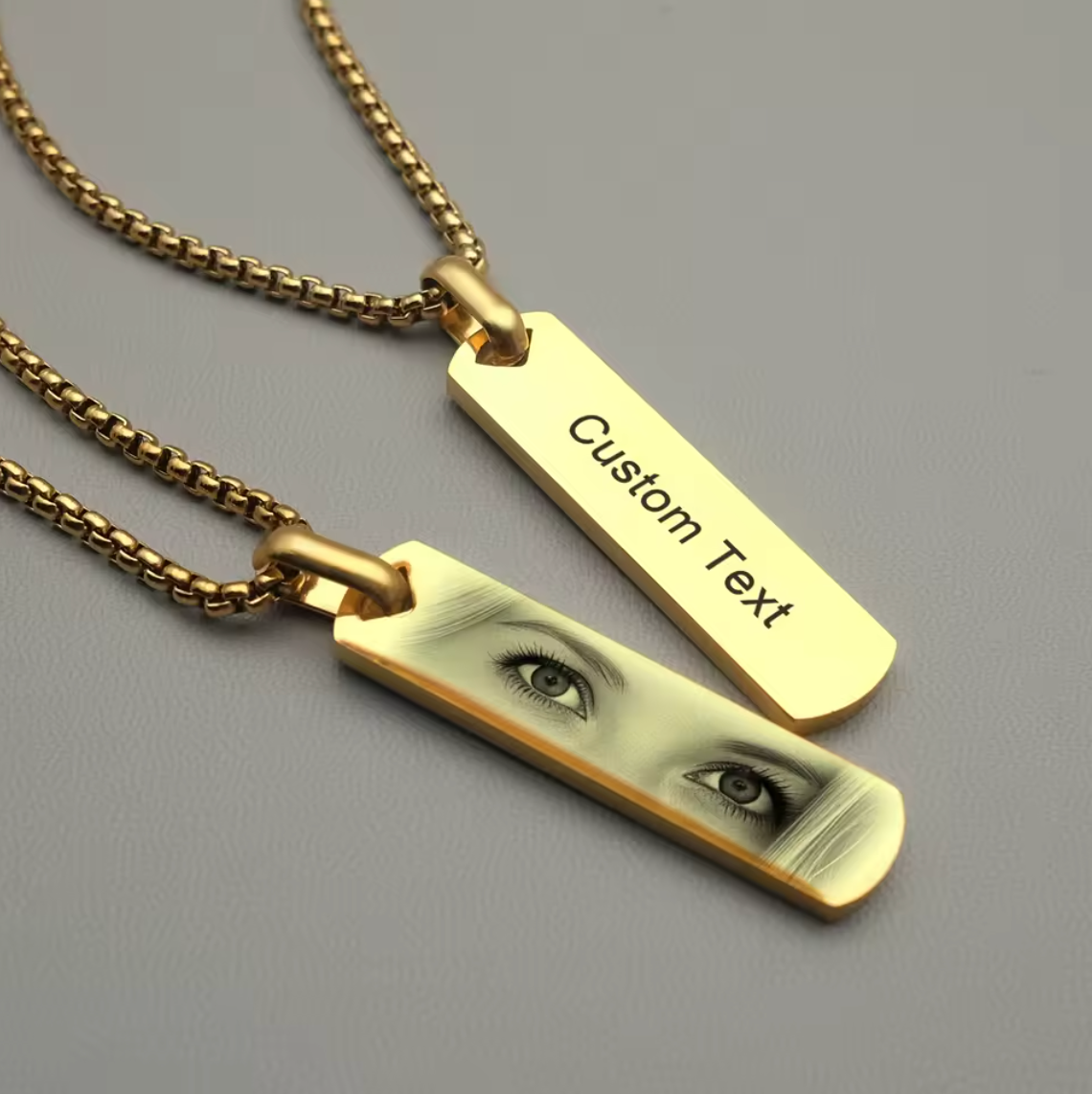 a rectangular gold necklace pendant with a custom printed photo of a young woman's eyes
